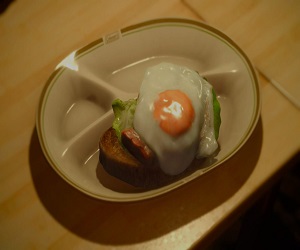 slice of bread topped with eggs, lettuce, ham and cheese 